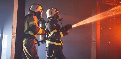 an image of firemen spraying a fire
