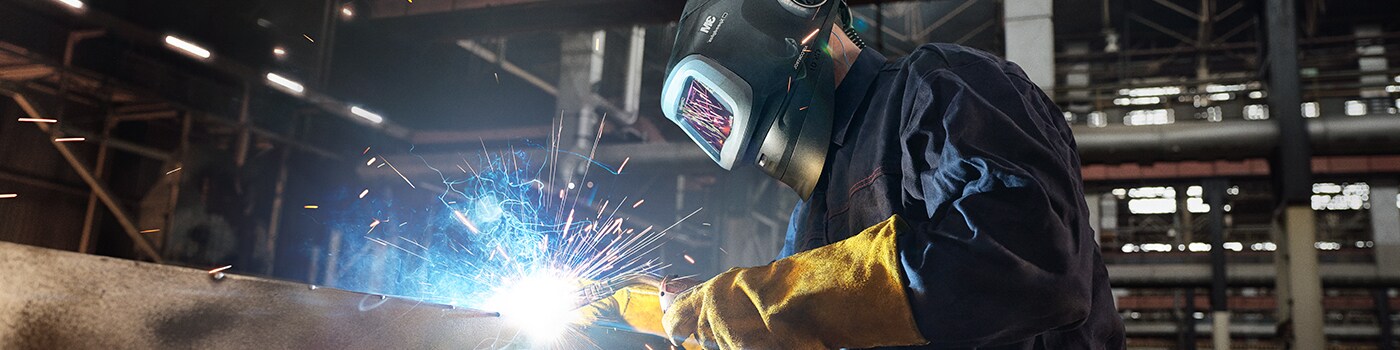 worker welding wearing welding helmet with PAPR
