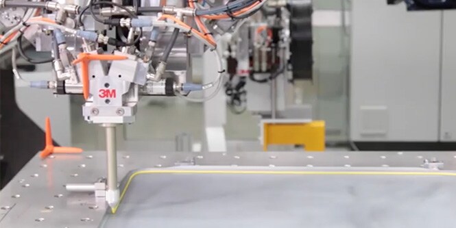 Video thumbnail showing the application of 3M adhesive via robotic arm.
