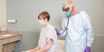 A health care provider with a patient using respiratory protection
