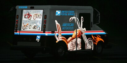 A black USPS Truck with a motorcycle graphic wrapped on it using 3M™ Scotchlite™ Reflective Film 5100R 
