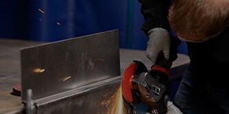 Worker finishing mild steel with Scotch-Brite Heavy Duty Surface Conditioning Disc
