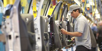 A man inspecting a row of car doors taken out from the vehicle body
