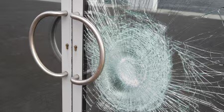 Glass door with impact breakage and splintering.
