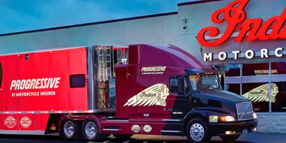 Indian motorcycles branded truck with reflective film outside of their brick and mortar storefront.
