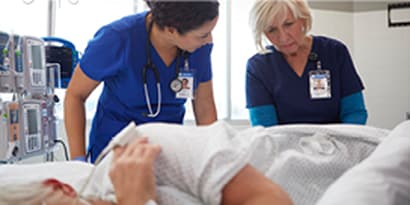 healthcare worker readjusting patient to prevent pressure injuries
