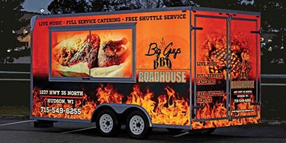 Trailer wrapped in a fiery BBQ graphic at night shining using 3M reflective film.
