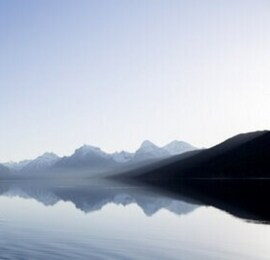 blue sky and a mountain reflecting off of water