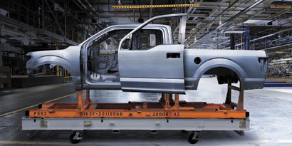 aluminum pickup truck on dolly in auto body shop
